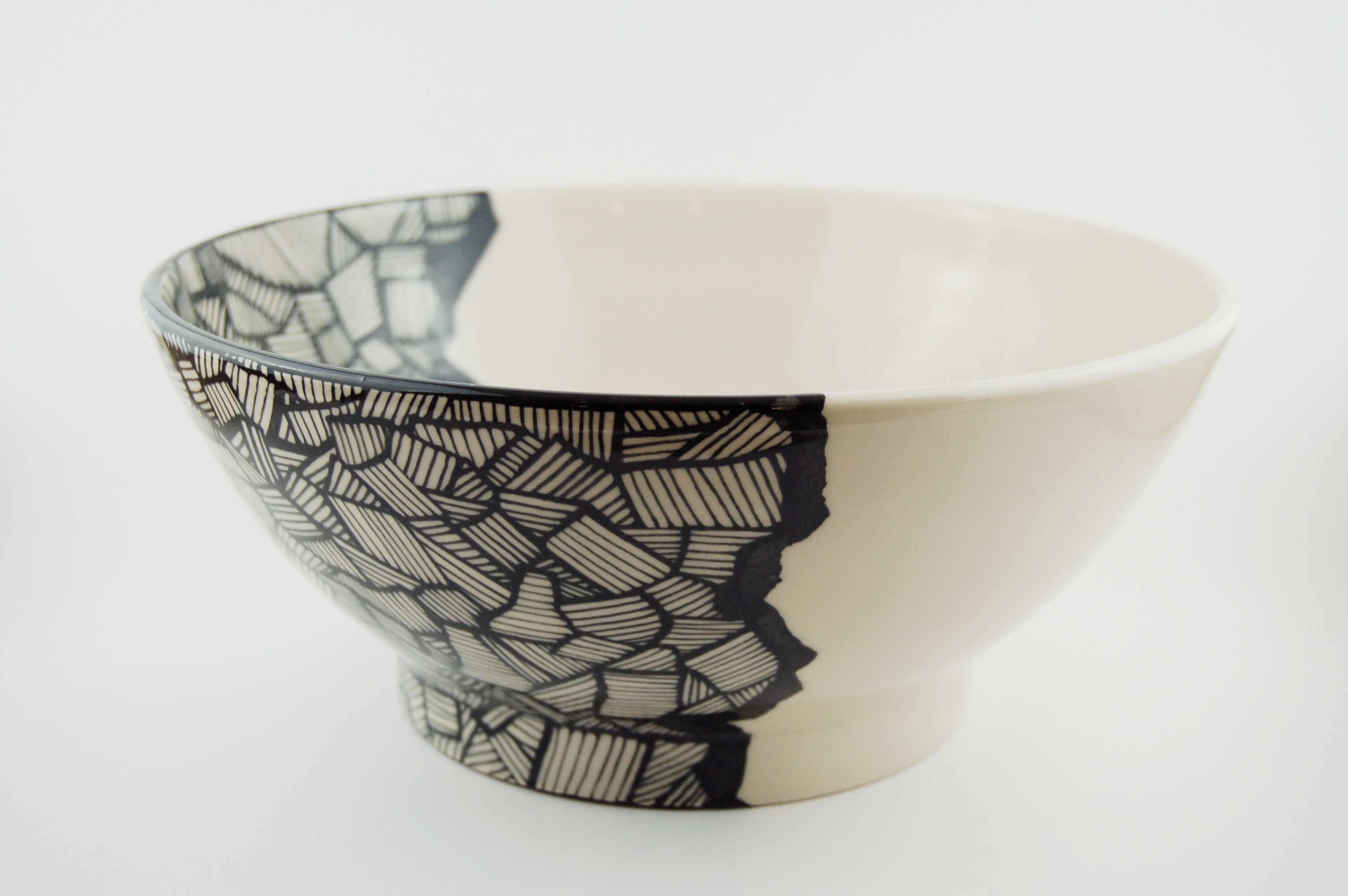 Ceramic bowl with black lines on off-white clay